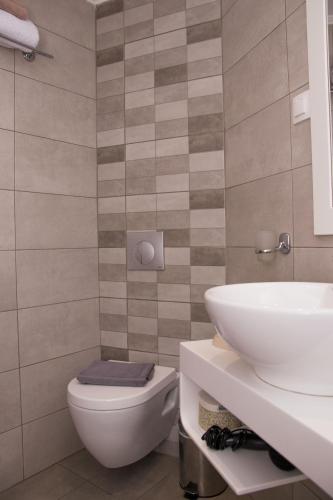 a bathroom with a white toilet and a sink at iria's apartments in Limenaria