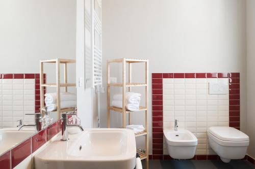 W łazience znajduje się umywalka, toaleta i lustro. w obiekcie Almarossa w Bolonii