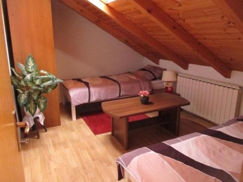 Habitación pequeña con 2 camas y mesa. en Apartman OPG Balja en Garešnica