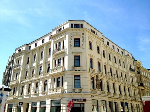 a large white building with a lot of windows at Sleepy Lion Hostel & Apartments Leipzig in Leipzig