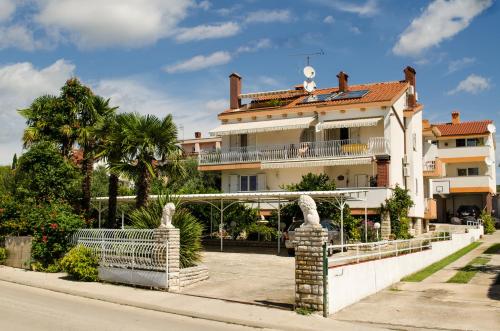 a large white building with a bridge in front of it at Pansion Adria in Sveti Filip i Jakov