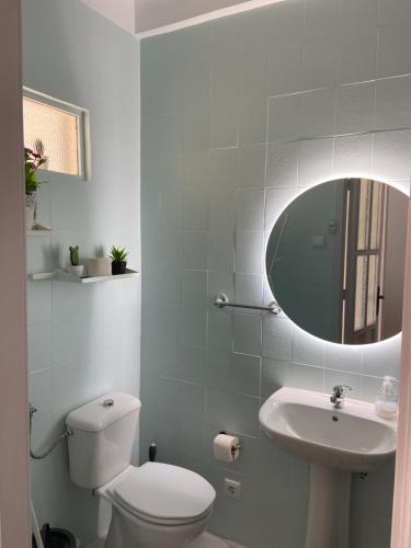 a bathroom with a toilet and a sink and a mirror at House T3 in Vila Nova de Gaia