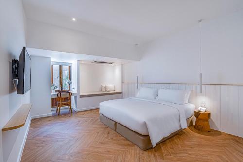 a bedroom with a large white bed and a television at Casa 33 Hatyai in Hat Yai
