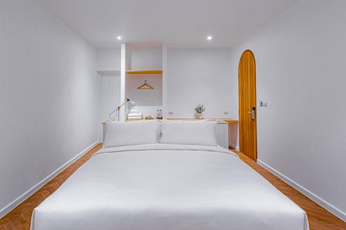 a white bedroom with a large white bed in it at Casa 33 Hatyai in Hat Yai