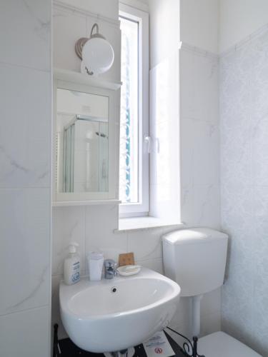 a white bathroom with a sink and a toilet at Affittacamere Golfo Della Luna in La Spezia