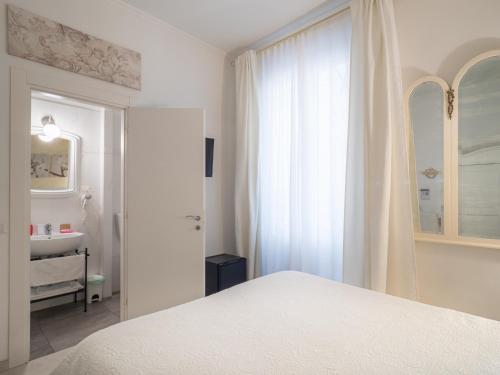 a white bedroom with a bed and a sink at Affittacamere Golfo Della Luna in La Spezia