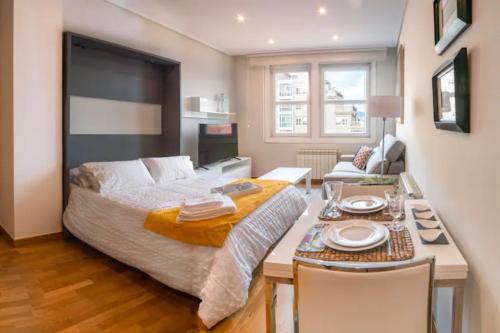 a bedroom with a bed and a table with chairs at Urzaiz Centro Vigo in Vigo
