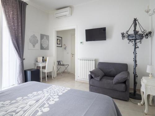 a bedroom with a bed and a chair and a tv at Affittacamere Golfo Della Luna in La Spezia