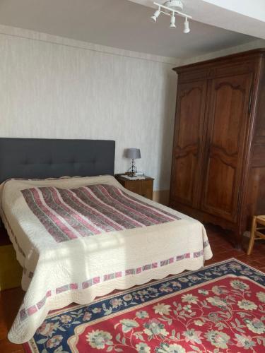 une chambre avec un lit et une armoire en bois dans l'établissement La maison de Jeannot, à Aisy-sous-Thil