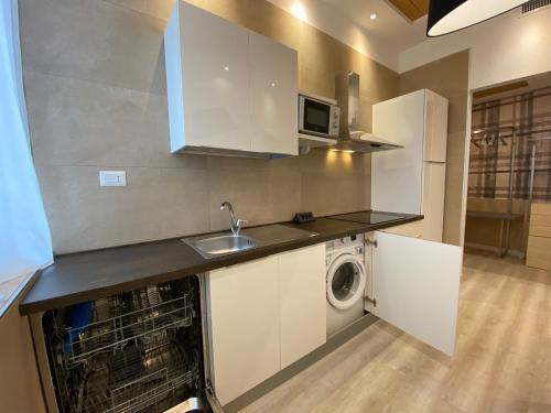 a kitchen with a sink and a washing machine in it at Residenze Romano Ristorante & SPA albergo diffuso - WHITE in Foggia