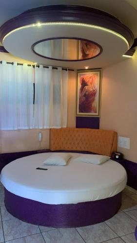 a bedroom with a large white bed in a room at Versat Motel in Barretos