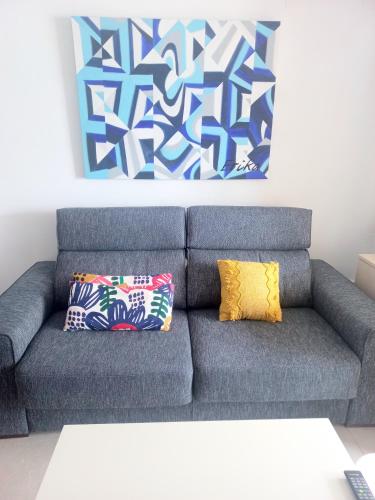 a blue couch with two pillows in a living room at Apartament Sony in Denia