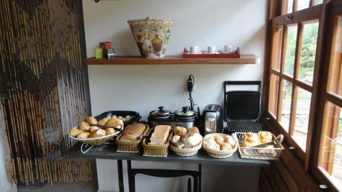 a table with some bread and baskets of bread at Pousada Chácara do Rio in Lumiar