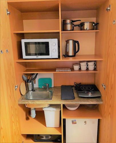 a kitchen with a sink and a microwave at Penzion Kersko in Hradišťko