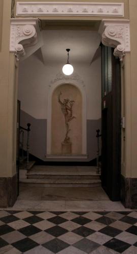 a room with a statue on the wall and a checkered floor at Affittacamere Golfo Della Luna in La Spezia