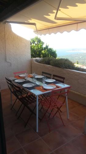 une table et des chaises assises sur une terrasse dans l'établissement Les EMERAUDES, à La Croix-Valmer