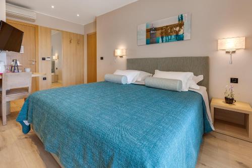 a bedroom with a large bed with a blue blanket at Residence Bepi Malugio in Primošten
