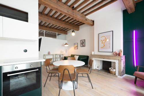 une cuisine et un salon avec une table et des chaises dans l'établissement L'irrésistible de Guise, à Nancy