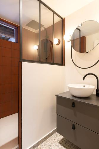 une salle de bain avec un lavabo et un miroir dans l'établissement L'irrésistible de Guise, à Nancy
