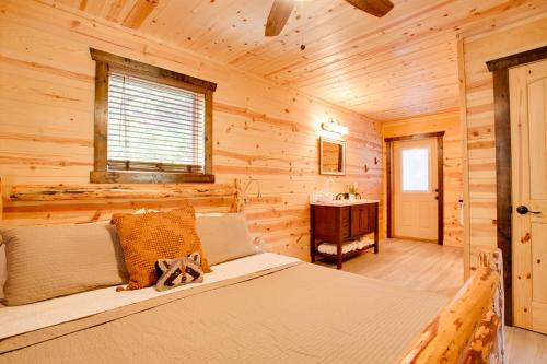 ein Schlafzimmer mit einem Bett in einem Blockhaus in der Unterkunft Lazy Raccoon Cabin in Starkeytown