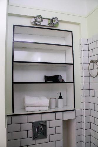 a shelf in a bathroom with towels on it at Manoir Le Parc near Paris & Disneyland in Villevaudé