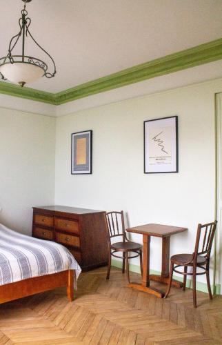 a bedroom with a bed and a table and chairs at Manoir Le Parc near Paris & Disneyland in Villevaudé