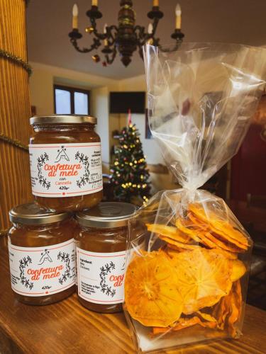 a table with three jars of honey and a christmas tree at Rifugio La Mestà in Trassilico