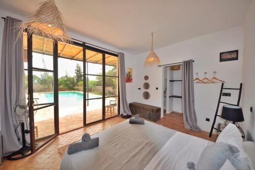 索维拉Villa Sunset - Maison entière的一间带大床的卧室和一个游泳池