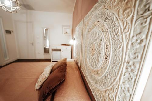 a headboard of a bed in a room at ALMASOL - Charme Experience in Castellana Grotte
