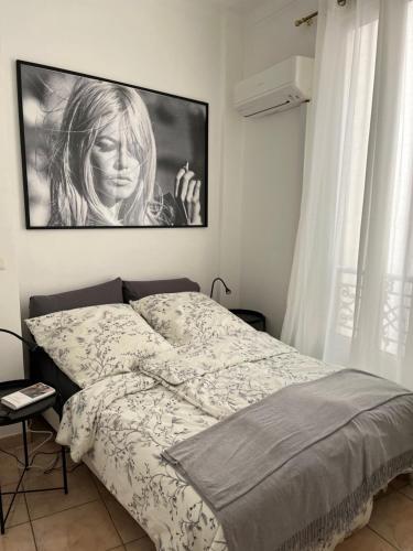 une chambre avec un lit avec un tableau sur le mur dans l'établissement ACCI Cannes Croisette, à Cannes