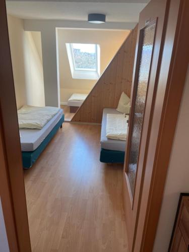 Habitación pequeña con 2 camas y escalera. en Fewo 5 en Elmenhorst