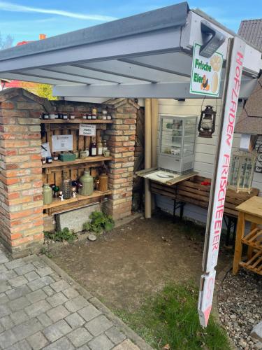 toldo sobre un edificio de ladrillo con una mesa y un mostrador en Fewo 5 en Elmenhorst