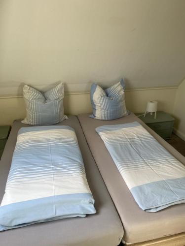 dos camas sentadas una al lado de la otra en una habitación en Fewo 5 en Elmenhorst