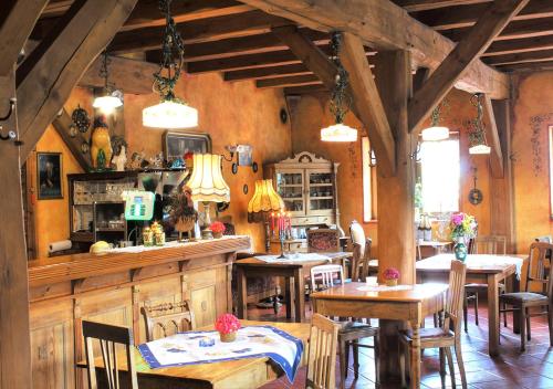 a restaurant with wooden tables and chairs in a room at Zajazd Pod Kogutkiem in Busewo