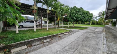 a car parked in front of a building with palm trees at Sleep&Go! Apartamento 2 habitaciones 4 personas Siquirres centro in Siquirres