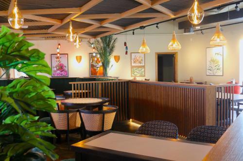 a restaurant with tables and chairs and pendant lights at Hex Wildlife Hotel at Yorkshire Wildlife Park in Doncaster