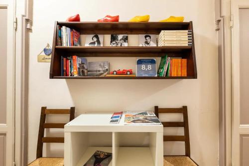 a white table and a shelf with books at Stop & Sleep Bergamo in Bergamo
