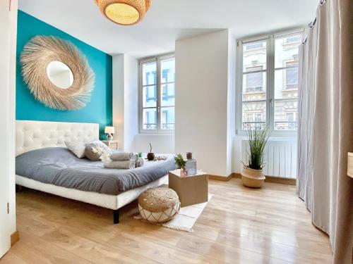 une chambre avec un lit et un mur bleu dans l'établissement Le convivial, appartement Centre ville Mulhouse, à Mulhouse
