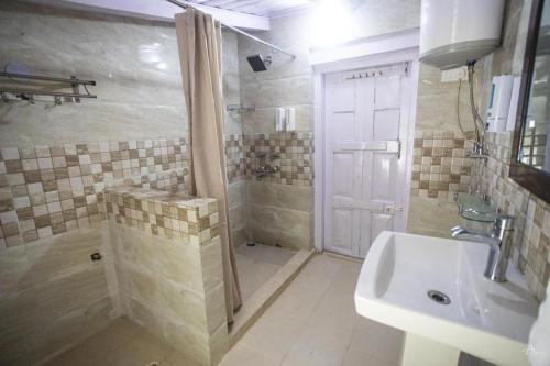 ein Badezimmer mit Dusche, Waschbecken und Toilette in der Unterkunft Dalhousie Heritage Cottage in Nainital