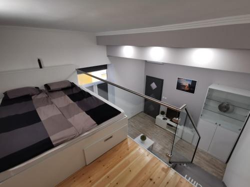 Dormitorio tipo loft con cama y escalera en AApartman Exclusive, en Pécs