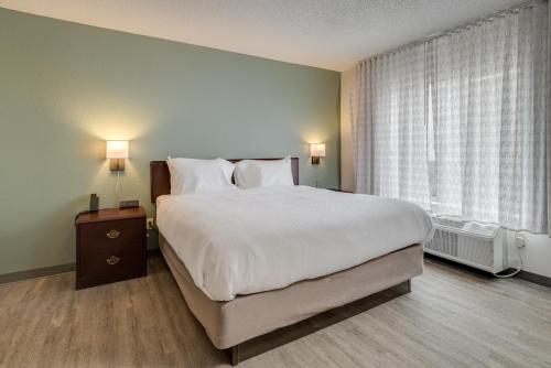 a bedroom with a large white bed and a window at MySuites Lawton in Lawton