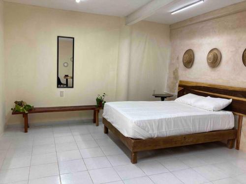 - une chambre avec un grand lit et un miroir dans l'établissement Casa Vera, à Campeche