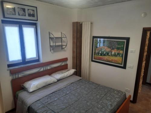 ein kleines Schlafzimmer mit einem Bett und einem Fenster in der Unterkunft Appartamento Savona in Savona