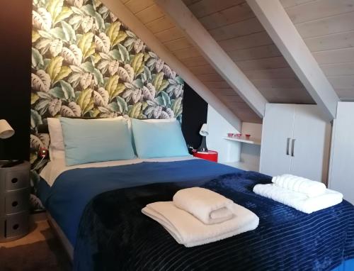 a bedroom with a blue bed with a floral wall at Argostoli loft in Argostoli