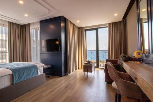 a hotel room with a bed and a couch and a desk at Espina Hotel in Antalya