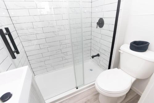 a white bathroom with a shower and a toilet at County Cove - Consecon Suite in Wellington