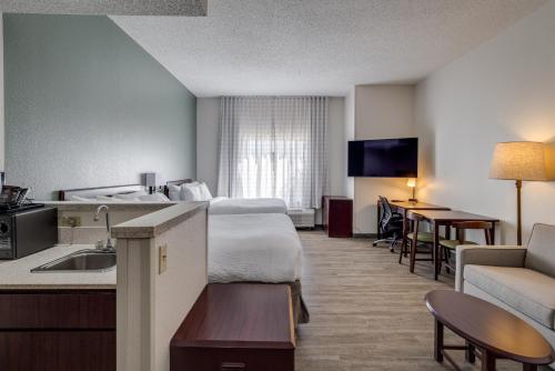 a hotel room with a bed and a kitchen at MySuites Lawton in Lawton