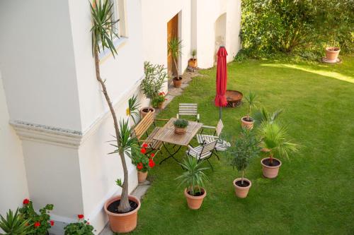 a garden with a table and chairs and potted plants at Turm zu Schloss Schedling in Trostberg an der Alz