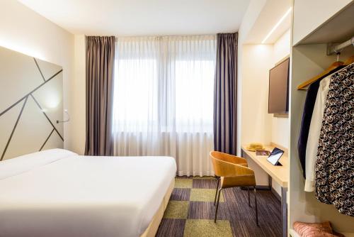 a hotel room with a bed and a window at Mercure Milano Agrate Brianza in Agrate Brianza