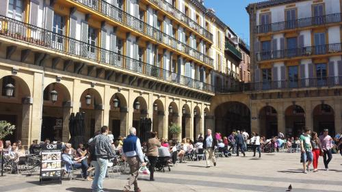 un grupo de personas caminando en un patio en un edificio en Pension Aries, en San Sebastián